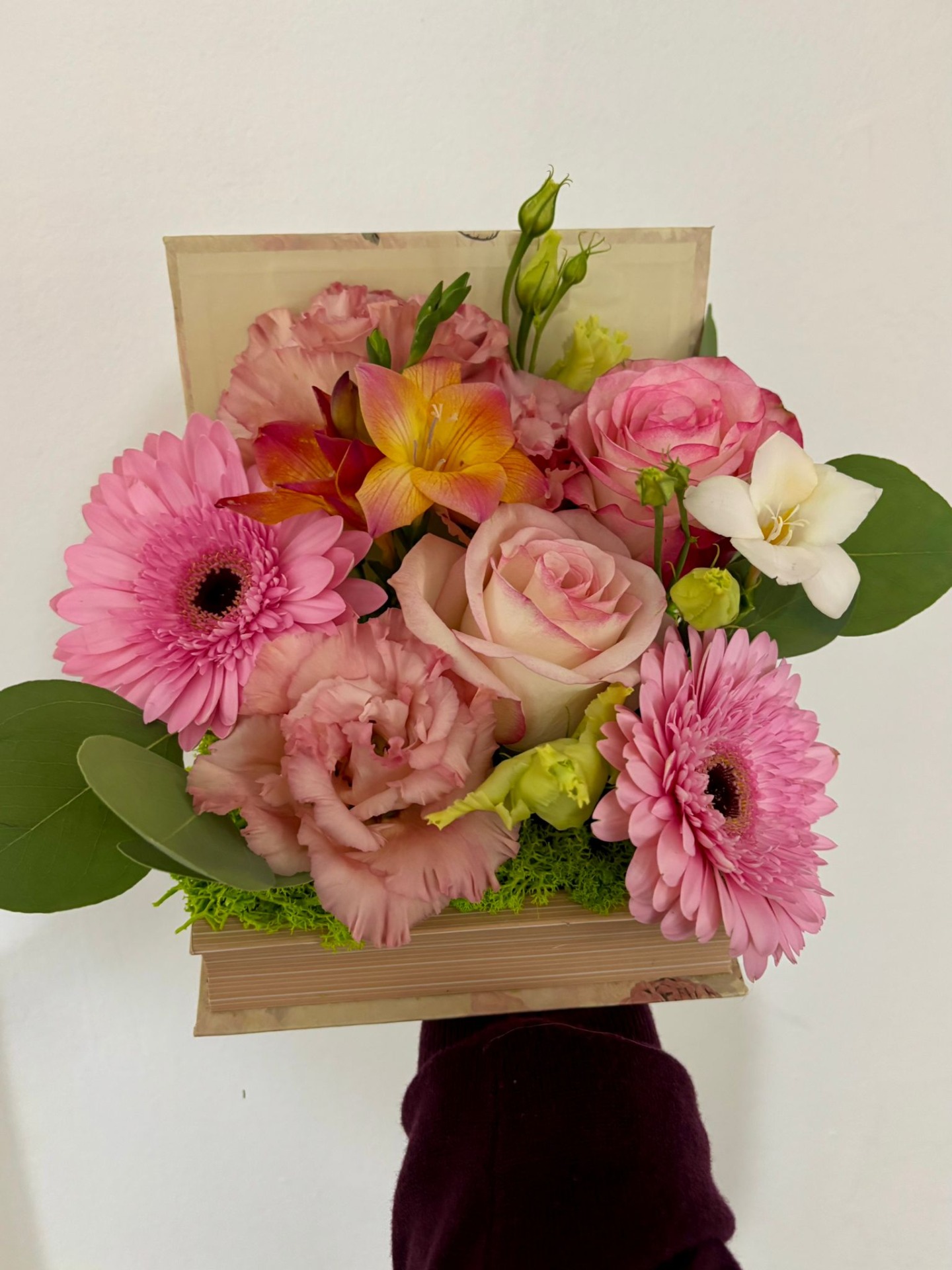 Aranjament tip carte, 2 gerbera roz, 2 trandafiri roz, 2 frezii, eustoma, eucalipt, licheni - 90 RON